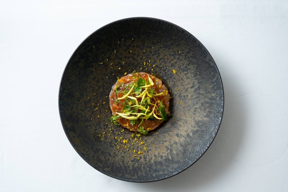 Tartare of autumn salmon with roe is served scattered with a mixture of homegrown herbs.