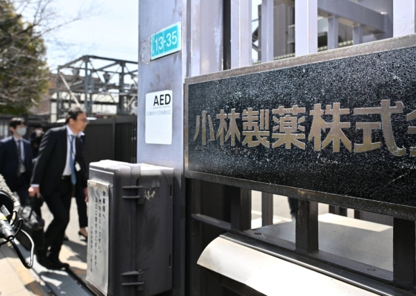 Health ministry officials enter Kobayashi Pharmaceutical's factory in the city of Osaka on March 30.