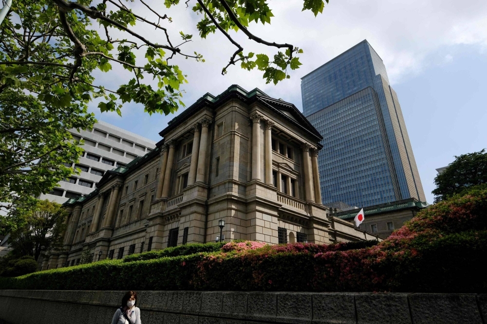 A woman walks past the Bank of Japan headquarters in central Tokyo on Friday.