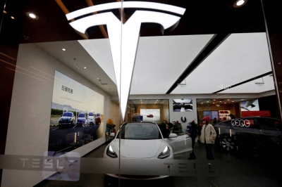Visitors check a Tesla Model 3 car next to a Model Y displayed at a showroom of the U.S. electric-vehicle maker in Beijing on Feb. 4.