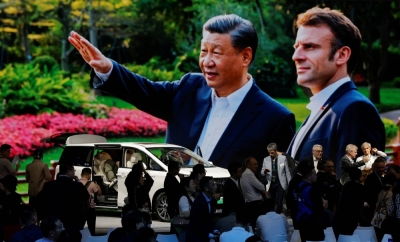A screen shows Chinese President Xi Jinping and French President Emmanuel Macron, at the GAC Motor booth at the Beijing International Automotive Exhibition in Beijing on Thursday.