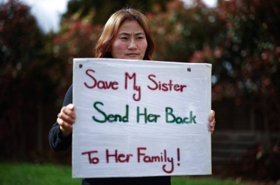 Kim Kyu-li holds a protest placard at her home in southwest London. 