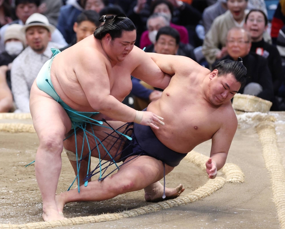 Kotonowaka (left) competes at the Spring Basho in Osaka in March. The grandson of former yokozuna Kotozakura has decided to take on the legend's ring name.