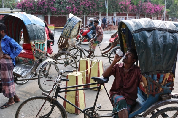 A rickshaw driver drinks water as he rests during ongoing heat-wave in Dhaka, Bangladesh, on Tuesday.