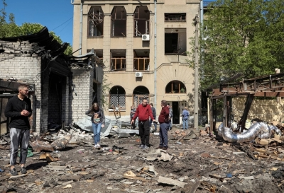 Local residents look at damage at a site of a Russian missile strike in Kharkiv, Ukraine, on Tuesday.