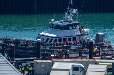 People believed to be migrants disembark from a British Border Force vessel as they arrive at the Port of Dover in Britain on Sunday. 


