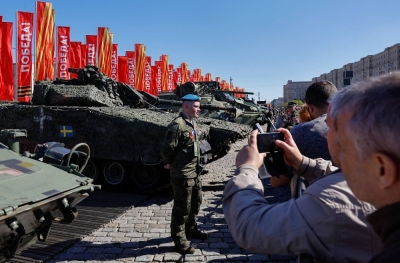 A guide stands next to a CV9040 infantry fighting vehicle and other military hardware at an exhibition displaying equipment captured by the Russian army from Ukrainian forces in the course of the Russia-Ukraine conflict, at the Victory Park open-air museum on Poklonnaya Gora in Moscow on Wednesday