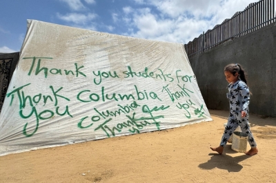 A girl walks past a tent sprayed with a message of gratitude to pro-Palestinian university students in the U.S. amid the ongoing conflict between Israel and Hamas, in Rafah in the southern Gaza Strip, on Thursday.