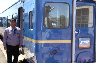 Jiro Suzuki, head of Kosaka Railroad Railpark in Kosaka, Akita Prefecture, stands next to a retired Akebono sleeper train that is now being used as a lodging facility, on April 22.