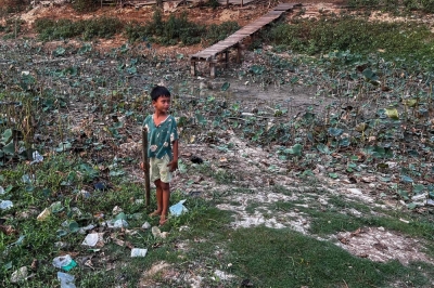 A boy next to a nearly dried-up lake during an electricity blackout in Yangon on Thursday