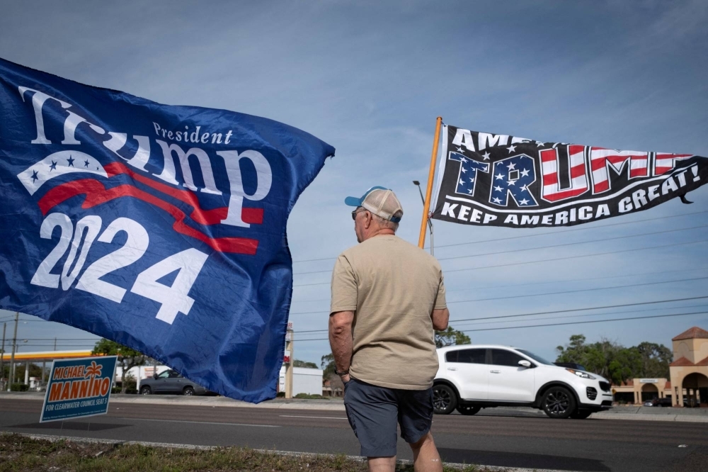 A supporter of Republican presidential candidate and former U.S. President Donald Trump waves a flag during a gathering in Palm Harbor, Florida, in March.