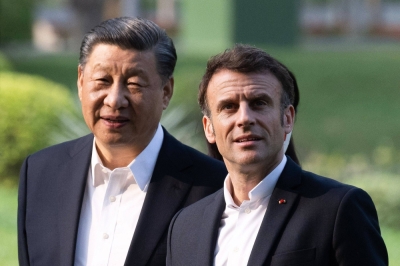 Chinese leader Xi Jinping and French President Emmanuel Macron visit the garden of the residence of the governor of Guangdong, China, in April last year.