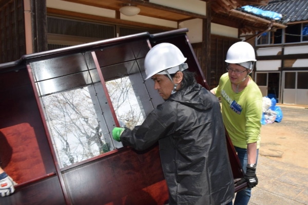 Volunteers help carry out furniture in the town of Anamizu, Ishikawa Prefecture on April 26. 
