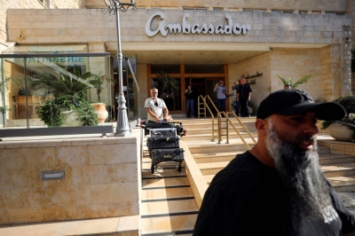 A man maneuvers media equipment following an Israeli police raid on an Al Jazeera de facto office at the Ambassador Hotel in Jerusalem on Sunday.