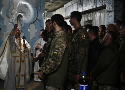 A chaplain blesses traditional cakes and eggs for servicemen of the 24th brigade of Ukrainian Army during the Easter service in an undisclosed location in the Donetsk region on Sunday.