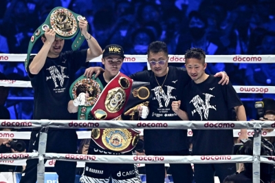 Naoya Inoue (second from left) celebrates after defeating Luis Nery to retain his IBF, WBA, WBC, and WBO super bantamweight titles at Tokyo Dome on Monday.
