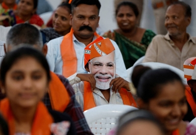 A supporter wears a mask depicting Indian Prime Minister Narendra Modi during an election campaign rally for Amit Shah, the Indian Home Minister and a leader of India's ruling Bharatiya Janata Party (BJP), in the city of Ahmedabad, in the Indian state of Gujarat, on April 30.