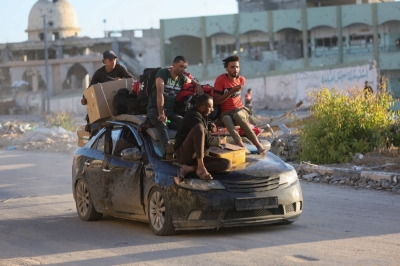Displaced Palestinians who fled Rafah ride atop a car in Khan Younis in the southern Gaza Strip on Monday. 