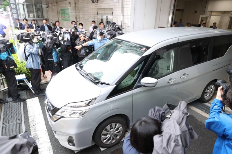 A vehicle carrying Seiha Sekine, the 32-year-old common-law husband of the deceased Tokyo couple's first daughter, leaves a police station in Tokyo's Shinagawa Ward on Tuesday.