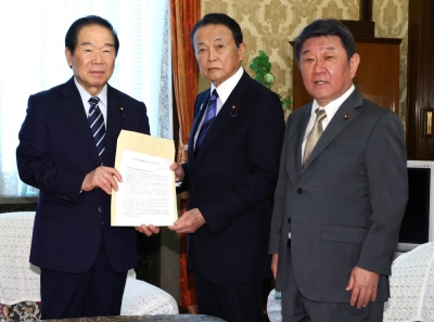 Taro Aso (center), vice president of the Liberal Democratic Party, hands the party's proposals for securing a sufficient number of imperial family members to Lower House Speaker Fukushiro Nukaga (left) at the parliamentary building on April 26.