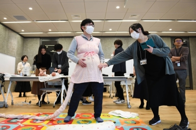 Sony employees simulate the physical sensations of pregnancy at the company’s headquarters in Tokyo in February. The simple power of numbers can begin to remake workplace cultures, but many Japanese women still struggle to balance their careers with domestic obligations.