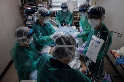 Medical workers take care of a COVID-19 patient on a mechanical ventilator, in a negative pressure room in an intensive care unit at St. Marianna University School of Medicine Yokohama City Seibu Hospital in Yokohama in August 2021.