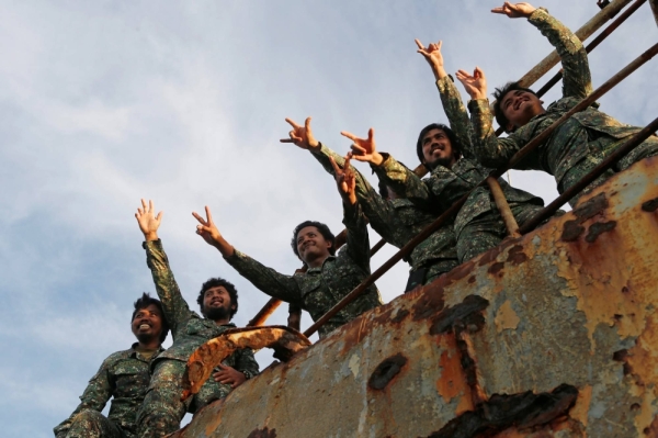 Philippine Marines wave to Philippine Navy personnel and the media during a resupply mission at their military outpost, the BRP Sierra Madre, a warship run aground in the disputed Second Thomas Shoal in 1999, in the South China Sea, in March 2014.