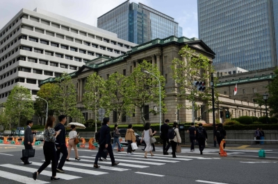People walk near the Bank of Japan headquarters in Tokyo on April 26.