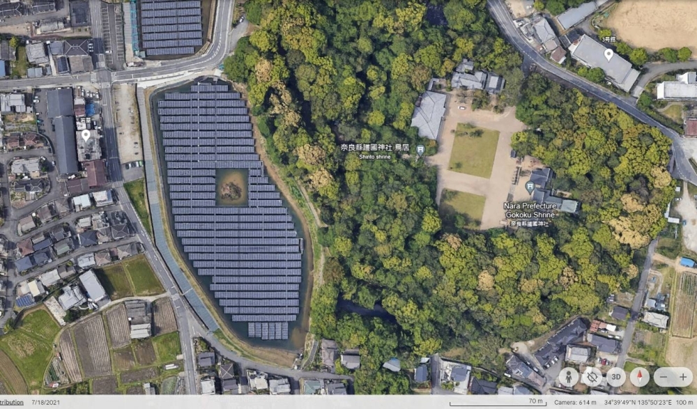 A Google Earth image of solar panels surrounding an ancient tomb on a pond in the city of Nara A Google Earth image of solar panels surrounding an ancient tomb on a pond in the city of Nara