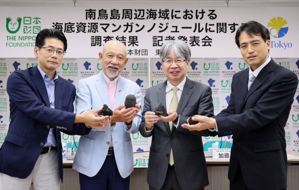 Giáo sư Yasuhiro Kato thuộc Khoa Sau đại học của Đại học Tokyo (giữa bên phải) và Yohei Sasakawa, Chủ tịch Quỹ Nippon (bên trái), đang cầm các nốt mangan, một nguồn tài nguyên dưới đáy biển được tìm thấy ở vùng biển xung quanh Minamitorishima, Tokyo, vào thứ sáu. Giáo sư Yasuhiro Kato thuộc Khoa Sau đại học của Đại học Tokyo (giữa bên phải) và Yohei Sasakawa, Chủ tịch Quỹ Nippon (bên trái), đang cầm các nốt mangan, một nguồn tài nguyên dưới đáy biển được tìm thấy ở vùng biển xung quanh Minamitorishima, Tokyo, vào thứ sáu.