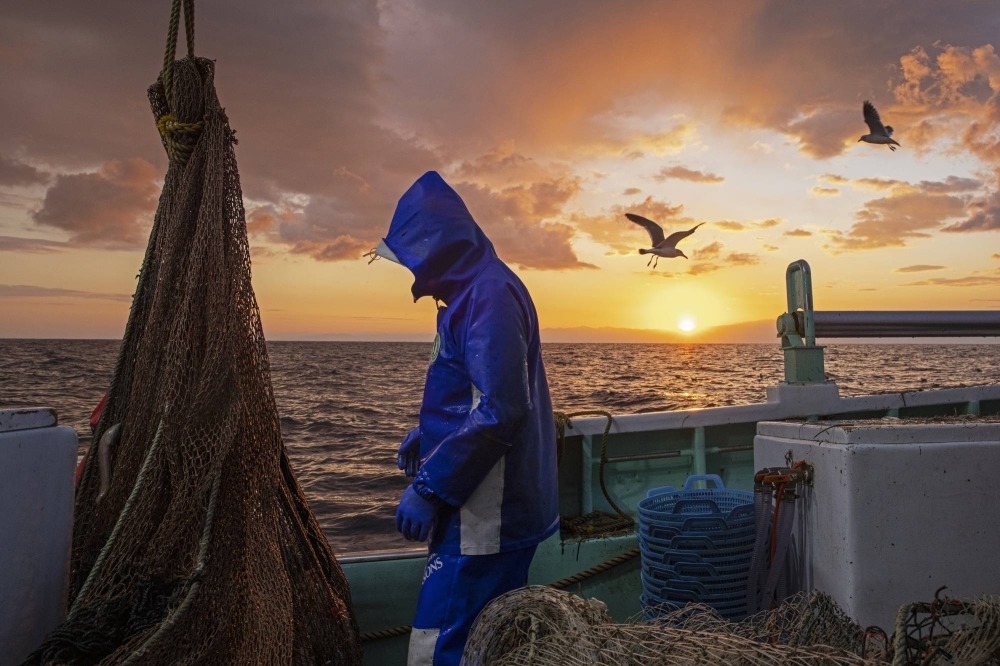 A fisherman on board a snow crab vessel in the sea west of the Noto Peninsula in November 2021. The fishing industry has tended to voice concerns about the impacts of offshore wind power, but examples from around the world show that offshore wind can coexist with fishers. A fisherman on board a snow crab vessel in the sea west of the Noto Peninsula in November 2021. The fishing industry has tended to voice concerns about the impacts of offshore wind power, but examples from around the world show that offshore wind can coexist with fishers.