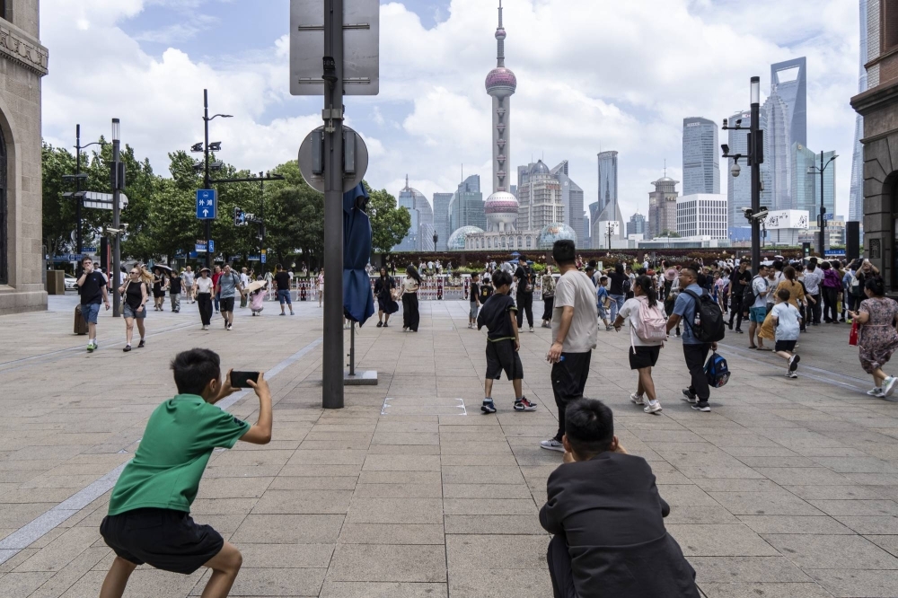 Los peatones toman fotografías en la calle Nanjing, cerca del Bund en Shanghai, el 27 de julio. Los peatones toman fotografías en la calle Nanjing, cerca del Bund en Shanghai, el 27 de julio.