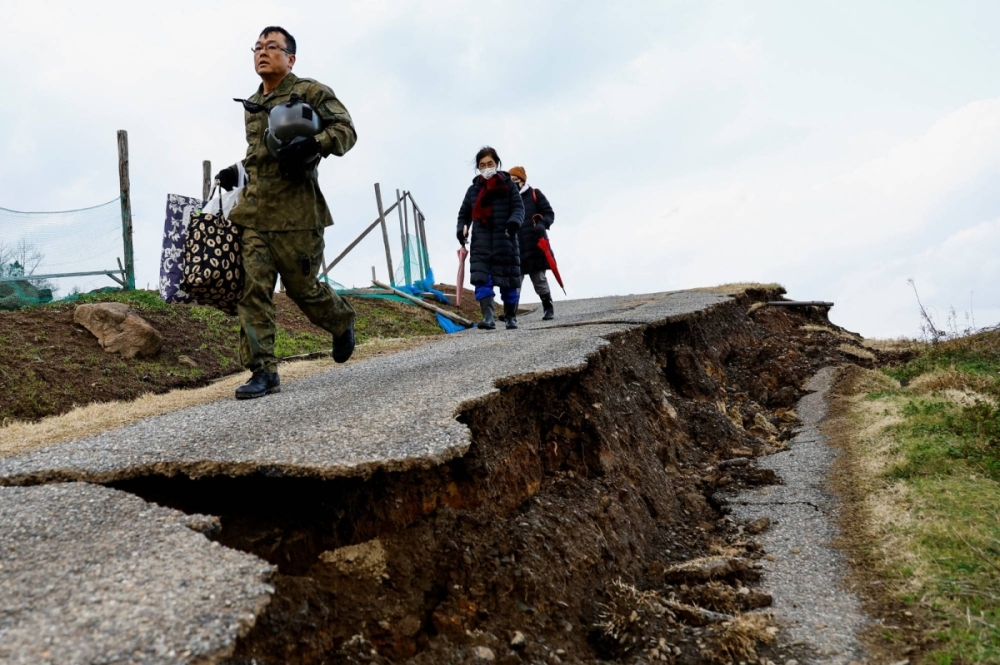 A Self-Defense Forces member leads residents in an isolated area of Wajima, Ishikawa Prefecture, to a helicopter on Jan. 6 in the aftermath of a major earthquake on the Noto Peninsula. A Self-Defense Forces member leads residents in an isolated area of Wajima, Ishikawa Prefecture, to a helicopter on Jan. 6 in the aftermath of a major earthquake on the Noto Peninsula.