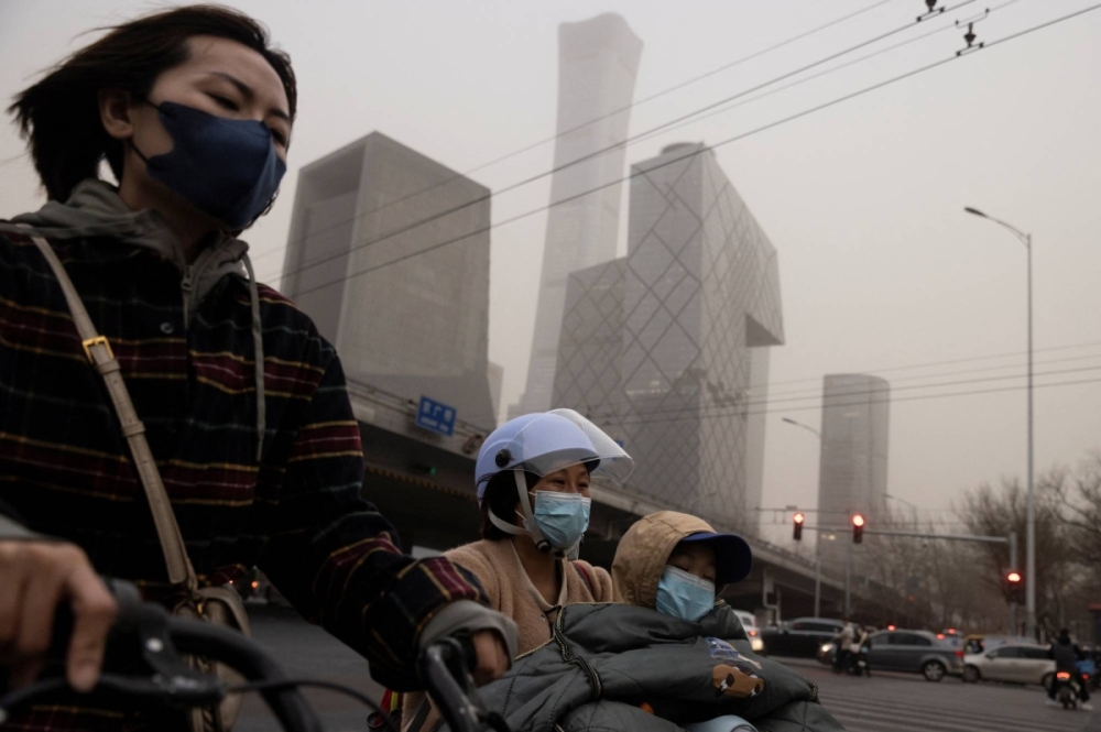 People wear face masks on a day with a high level of pollution in Beijing in March of last year. People wear face masks on a day with a high level of pollution in Beijing in March of last year.