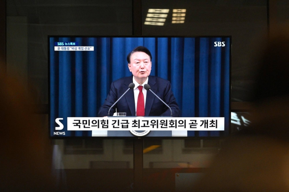 South Korea's President Yoon Suk-yeol is seen speaking on a television in a train station in Seoul late Tuesday evening. During the broadcast, he declared emergency martial law, saying the step was necessary to protect the country from South Korea's President Yoon Suk-yeol is seen speaking on a television in a train station in Seoul late Tuesday evening. During the broadcast, he declared emergency martial law, saying the step was necessary to protect the country from