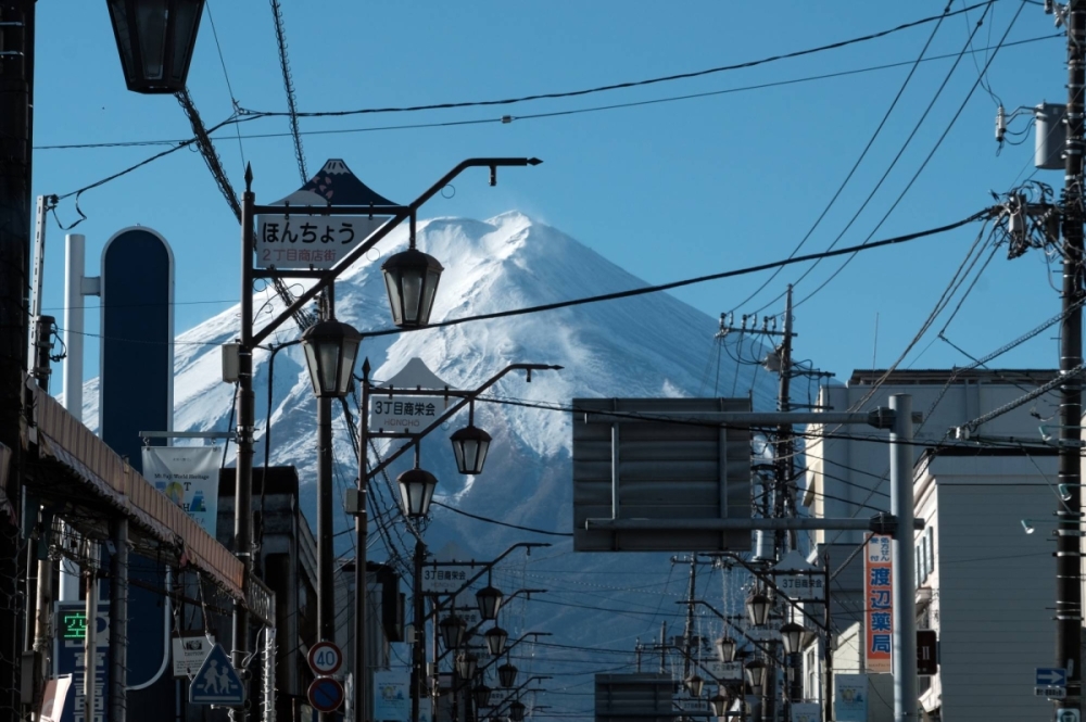 A view of Mount Fuji from a shopping street in Fujiyoshida, Yamanashi Prefecture. The first snowcap of 2024 on Mount Fuji was delayed about a month amid record-setting temperatures in Japan throughout much of the year. A view of Mount Fuji from a shopping street in Fujiyoshida, Yamanashi Prefecture. The first snowcap of 2024 on Mount Fuji was delayed about a month amid record-setting temperatures in Japan throughout much of the year.