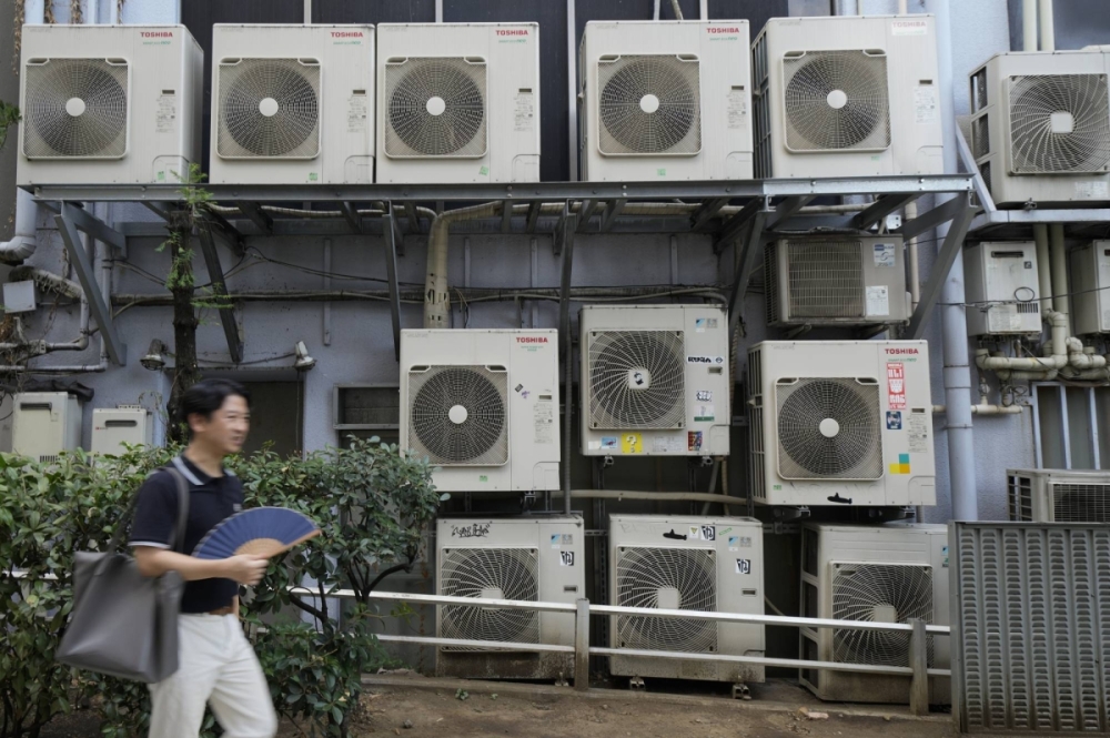 A pedestrian walks past air conditioning units in Tokyo in July. Air conditioners sold well in 2024 and even into the autumn season as high temperatures persisted. A pedestrian walks past air conditioning units in Tokyo in July. Air conditioners sold well in 2024 and even into the autumn season as high temperatures persisted.
