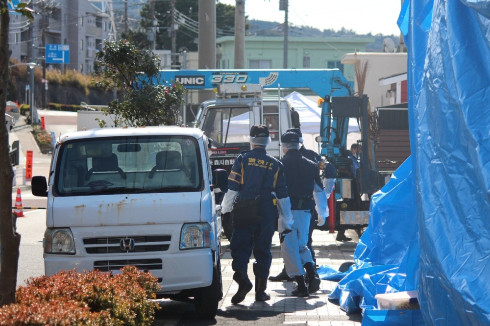 Investigators pursue a criminal case in the town of Oshima in Tokyo in January.