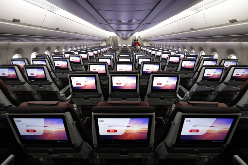 In-flight entertainment screens on the economy class seats of an Airbus SE A350-1000 aircraft operated by Japan Airlines at the company's hangar at Haneda Airport in January 2024. The airline is relying on new aircraft for half of its planned emissions cuts. In-flight entertainment screens on the economy class seats of an Airbus SE A350-1000 aircraft operated by Japan Airlines at the company's hangar at Haneda Airport in January 2024. The airline is relying on new aircraft for half of its planned emissions cuts.