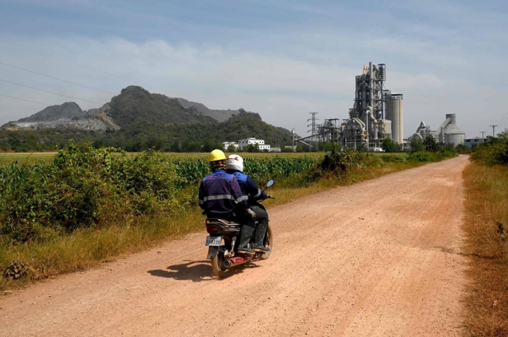 Workers travel by motorcycle near the Chip Mong Insee cement factory in Kampot province on Jan. 9. Workers travel by motorcycle near the Chip Mong Insee cement factory in Kampot province on Jan. 9.