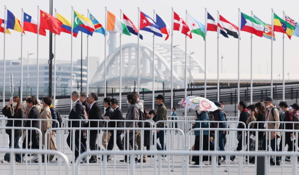 People walk to the Osaka Expo venues on the Yumeshima artificial island on Saturday to participate in a three-day test run involving visitors ahead of its grand opening next Sunday.