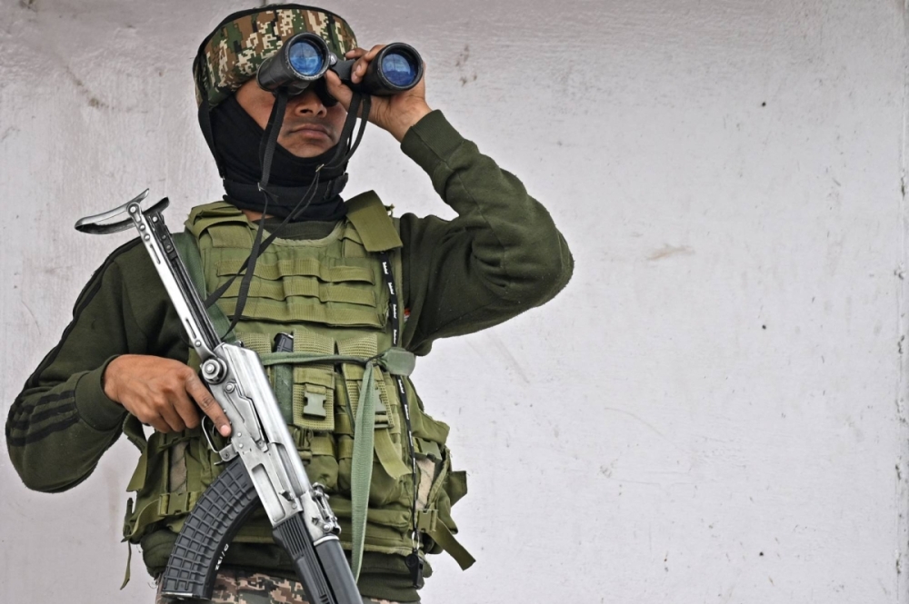 Hindistan'ın kontrolündeki Keşmir'de bir paramiliter asker, pazartesi günü Srinagar'da bir ticari binanın tepesinde dürbünle gözetleme yapıyor. Hindistan'ın kontrolündeki Keşmir'de bir paramiliter asker, pazartesi günü Srinagar'da bir ticari binanın tepesinde dürbünle gözetleme yapıyor.