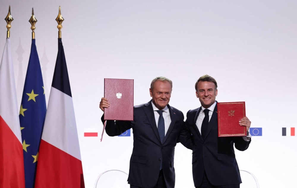 French President Emmanuel Macron (right) and Polish Prime Minister Donald Tusk pose after signing the French-Polish Friendship and Strategy Pact following their meeting at the Nancy's town hall on Stanislas square in Nancy, eastern France, on Friday.