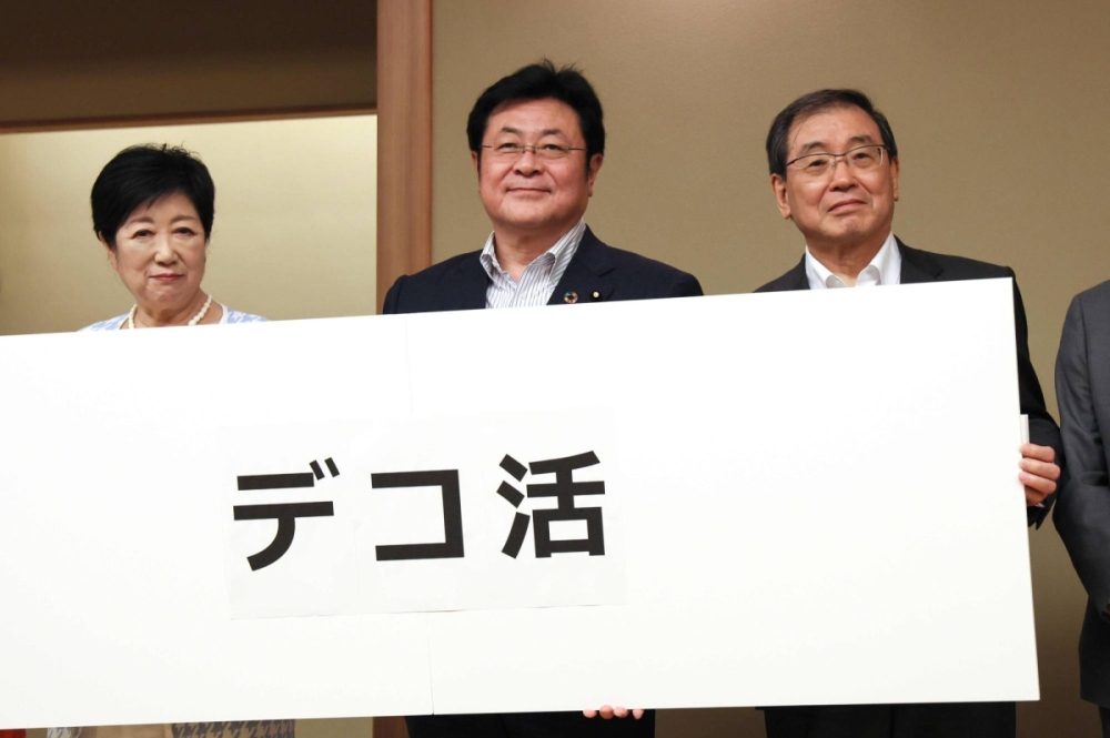Tokyo Gov. Yuriko Koike (left), then-Environment Minister Akihiro Nishimura (center) and then-Keidanren Chairman Masakazu Tokura promote the decokatsu program during an event in Tokyo in July 2023. Tokyo Gov. Yuriko Koike (left), then-Environment Minister Akihiro Nishimura (center) and then-Keidanren Chairman Masakazu Tokura promote the decokatsu program during an event in Tokyo in July 2023.