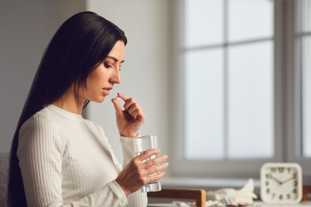 Pills tablet in hand of the girl in the room. Concept virus cold pill sick flu sickness headache flu illness. Pills tablet in hand of the girl in the room. Concept virus cold pill sick flu sickness headache flu illness.