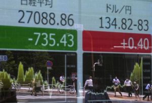 TUMBLING IN TOKYO Pedestrians are reflected on an electronic share price board showing the numbers of the Tokyo Stock Exchange (left) and a foreign-exchange board showing the yen’s rate against the dollar in Tokyo on Monday, June 13, 2022. AFP PHOTO
