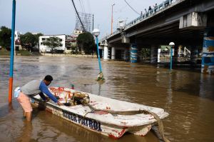 READY A man readies a boat at the Marikina River, which overflowed at the height of Typhoon ‘Karding’ on Sunday night, Sept. 25, 2022. The city government enforced mandatory evacuation of residents when the third alarm was raised. PHOTO BY JOHN ORVEN VERDOTE