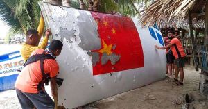 Philippine Coast Guard (PCG) personnel carry debris, which the Philippine Space Agency said has markings of the Long March 5B (CZ-5B) Chinese rocket launched on July 24, after it was found in waters off Mamburao town, Occidental Mindoro province in August 2022. PCG PHOTO VIA AP