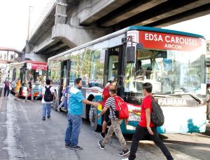 Passengers board a bus at the Edsa Carousel busway at the Mega Q-Mart station in Quezon City. THE monthlong 24/7 free ride on the Edsa Busway rolled out on Thursday, December 1, as the government’s gift to commuters this Christmas season. (PHOTO BGY: MIKE DE JUAN)