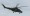 A military helicopter flies during Russia's invasion of Ukraine at an unidentified location